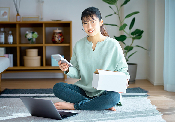 パソコンとスマホを持っている女性